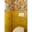 Witte porseleinen toilet tegen een gele tegelwand van Zelliges Alhambra Tournesol 10x10