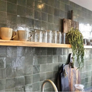 Houten floating shelf tegen groene wand met Zelliges Alhambra handgemaakte tegels
