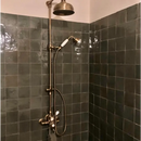 Vintage brass shower fixture with dual heads on dark tiles, Zelliges Alhambra stijl